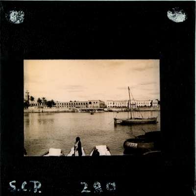 Lantern Slide: City viewed across river with boats