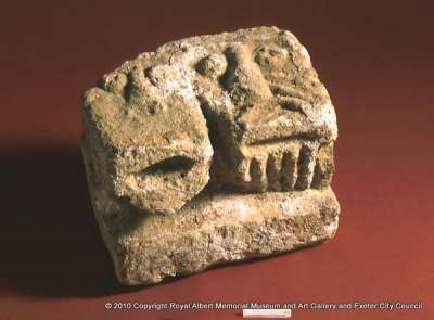 stone from a doorway showing two crudely carved heads