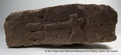 carved stone depicting an axe beside two objects ?astragali, possibly part of an altar