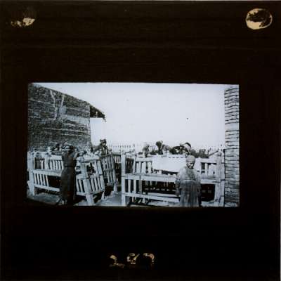 Lantern Slide: Group of men and boys with benches