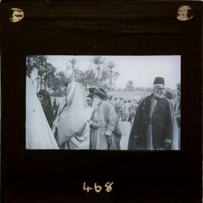 Lantern Slide: Men and women in local clothing with British soldiers in background