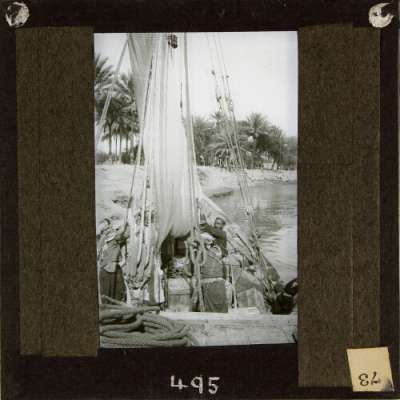 Lantern Slide: Local men raising sail of river boat